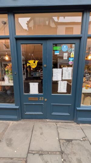 Blue wood-framed glass doors. Push from handles at centre to open.