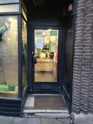 Black-framed glass door. Push from handle on left to open.