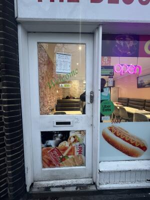 White metal-framed glass door. Push from handle on right to open.