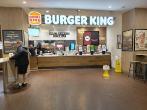 From entrance facing straight. Table on left. Counter at centre back. Table and stools along right.