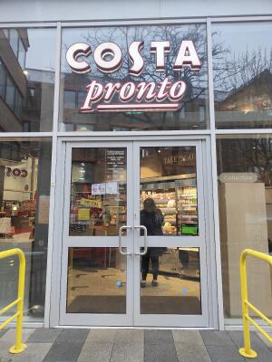 Grey metal-framed glass doors ahead. Pull from metal handles at centre to open.