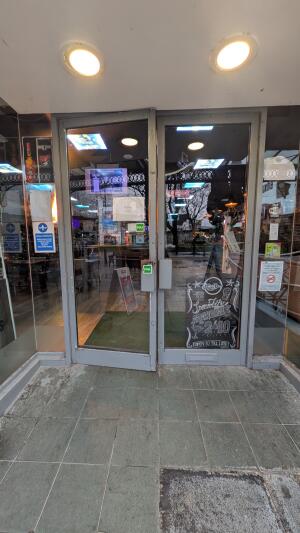 Grey metal-framed glass doors. Pull from handles at centre to open.