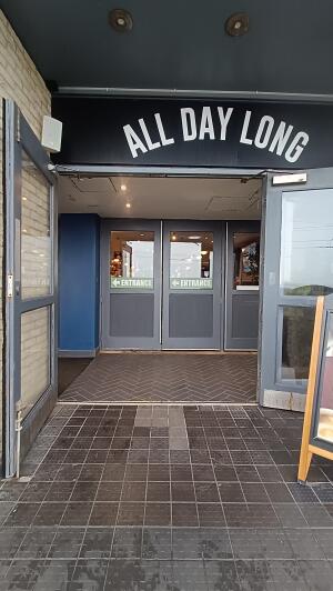 Grey framed glass doors to venue. Pull from handles at centre to open.