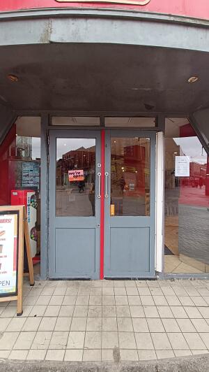 Grey wood-panelled glass doors. Pull from handles at centre to open.