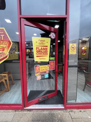 Red metal-framed glass door. Push from handle on right to open.