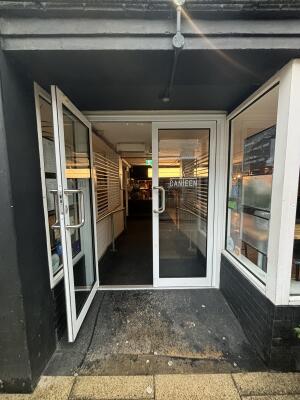 White metal-framed glass doors ahead. Pull from metal handles at centre to open.