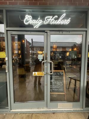 Grey metal-framed glass doors ahead. Push from handles at centre to open.