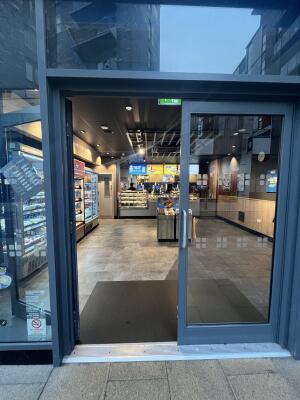 Grey metal-framed glass doors. Push from handle on right to open.