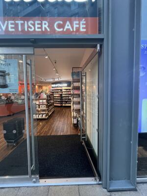 Glass doors with metal frame. Push from metal handles at centre to open.