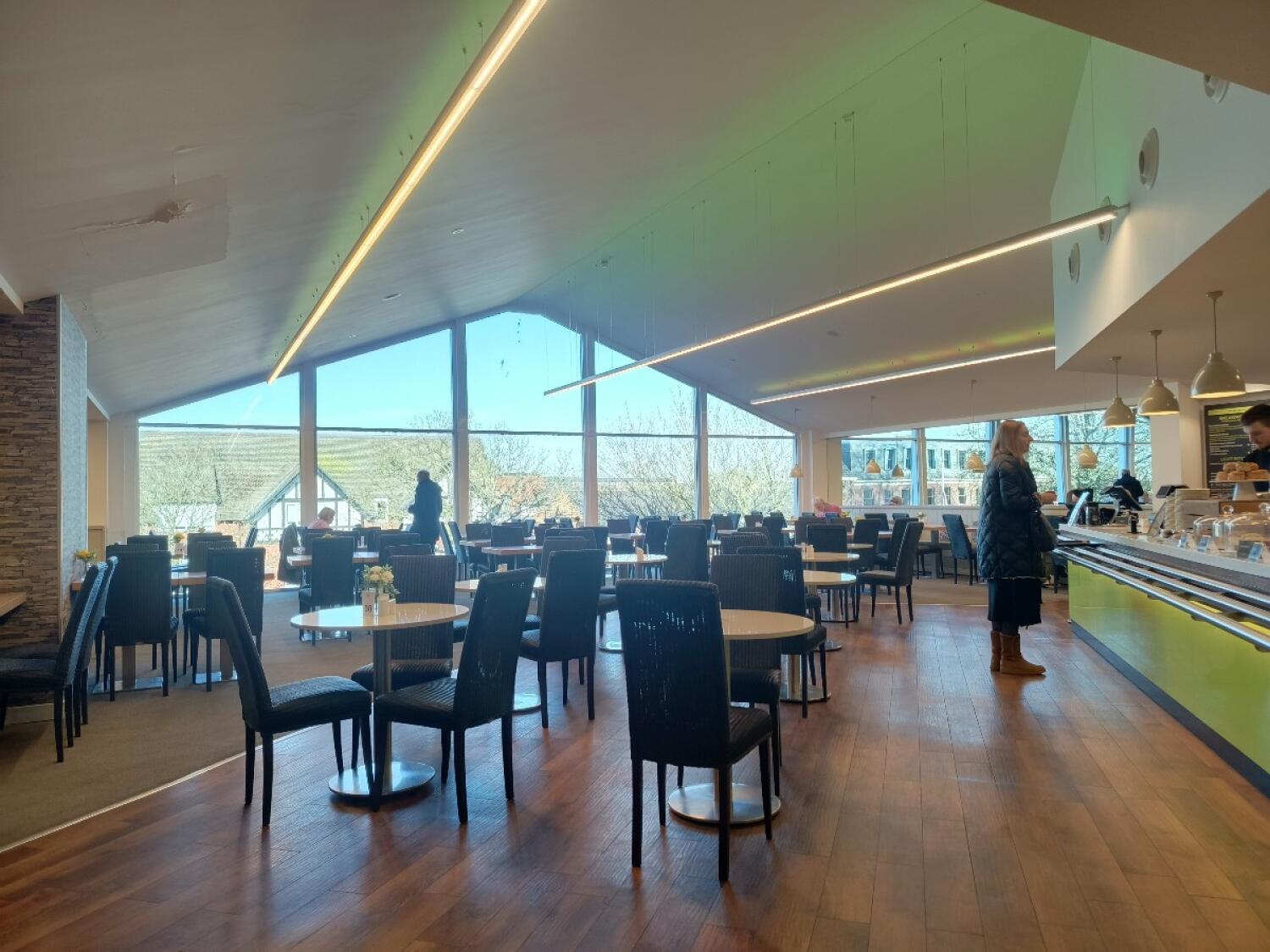 From counter facing left. Tables and chairs spread ahead. Counter along right.