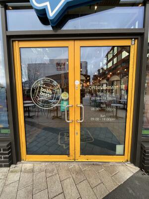Yellow metal-framed glass doors. Pull from metal handles at centre to open.
