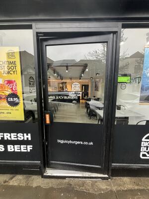 Black metal-framed glass door ahead. Push from handle on left to open.