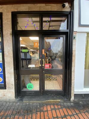 Black-framed glass door. Push from gold metal handle from centre to open.