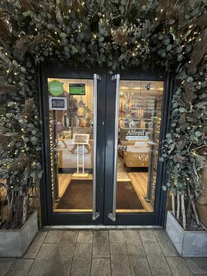 Black metal-framed glass doors. Pull from metal handles at centre to open.