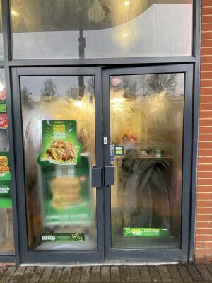 Black metal-framed glass doors. Push from handles at centre to open.