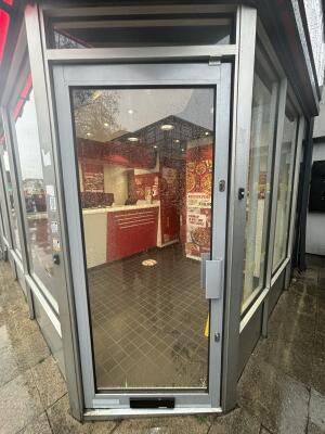 Grey metal-framed glass door ahead. Push from handle on right to open.