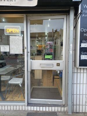 Silver metal-framed glass door ahead. Push from handle on left to open.