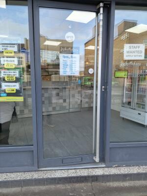 Grey metal-framed glass door ahead. Push from handle on right to open.