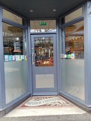 Grey wood-framed glass door ahead. Push from handle on left to open.