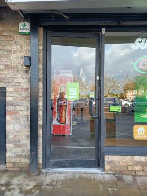 Black metal-framed glass door ahead. Push from handle on right to open.