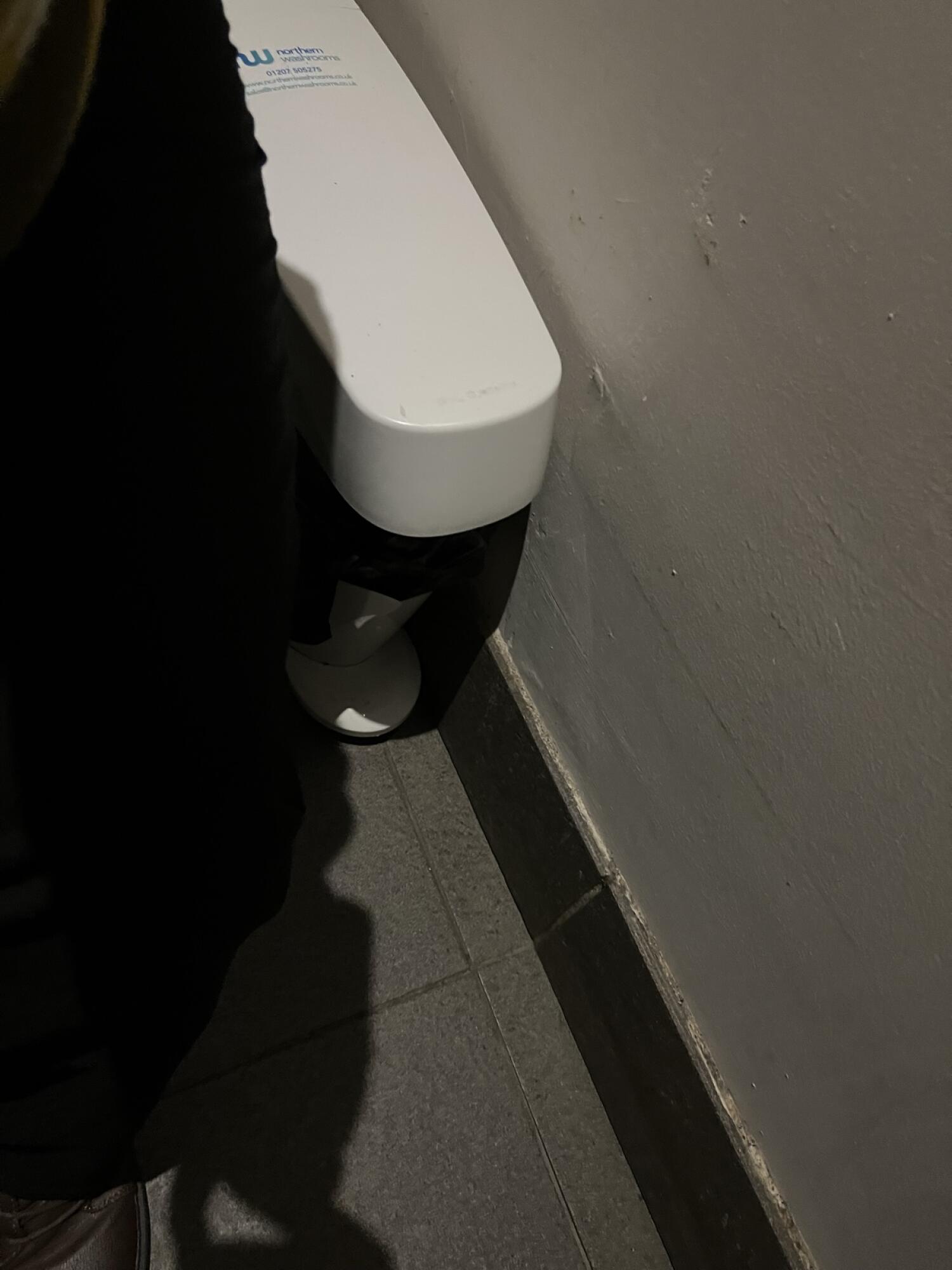 Toilet at back wall.