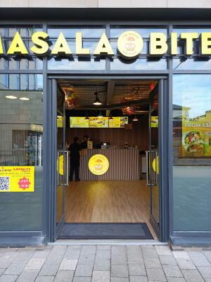Glass doors with dark metal frame ahead. Push from handles at centre to open.