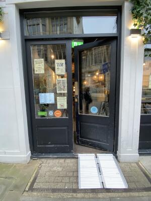 Black wood-framed glass door. Push from centre to open.