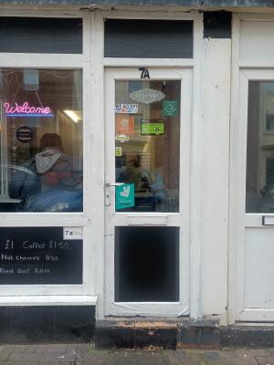 White wood-framed glass door ahead. Push from handle on left to open.