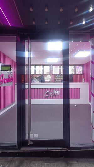 Black metal-framed glass door to venue. Push from metal handle on left to open.