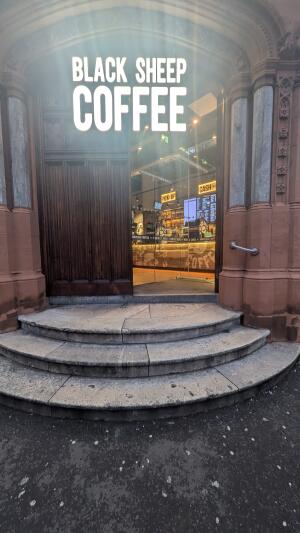 From street facing venue. Three steps up before doorway. Handrail on right.