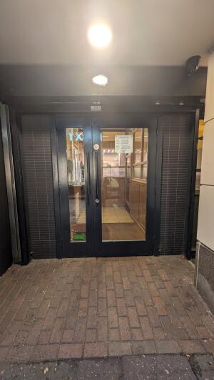 Black metal-framed glass doors. Pull from handles at centre to open.