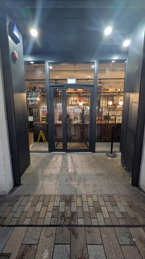 Black metal-framed glass door. Pull from handle on left t to open.