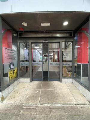 Black metal-framed glass doors. Automatic doors slide open from centre to each side.