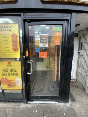 Black metal-framed glass door. Push from silver metal handle on left to open.