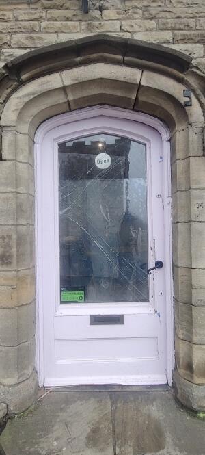 Light pink wooden framed glass door. Twist push metal handle on right to open.