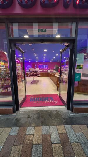 Black metal-framed automatic glass doors. Doors open inwards in center.