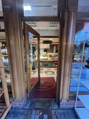 Wood-framed glass door. Push from handle on left to open.
