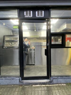 Black metal-framed glass door. Push from handle on right to open.