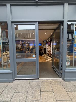 Grey metal-framed glass doors. Push from handles at centre to open.