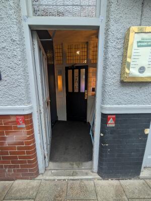 White door in front. Gold handle on right. Push to open.