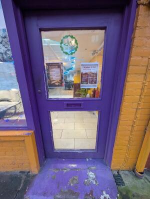 Purple wood-framed glass door. Push from handle on left to open.