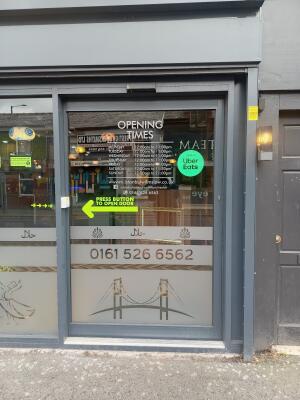 Grey metal-framed glass door ahead. Push button on left of door to open.