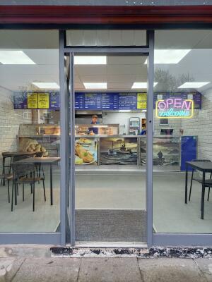 Grey metal-framed glass door. Push from handle on right to open.