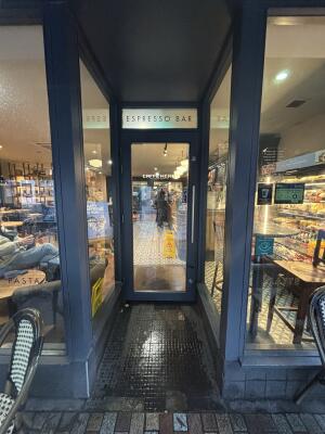 Opening ahead. Black framed glass door at back. Pull from handle on right to open.