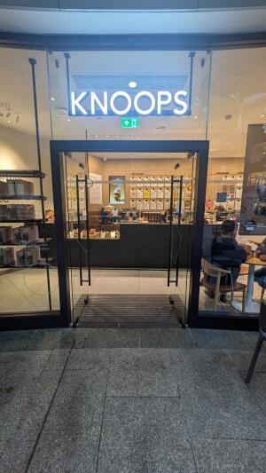 Glass doors with black metal frame. Push from handles at centre to open.