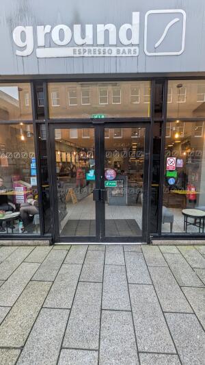 Black metal-framed glass doors. Push from handle at centre to open.
