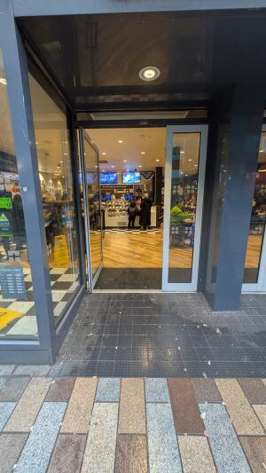 Grey metal-framed glass doors. Push from handles at centre to open.