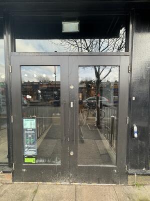 Black metal-framed glass doors ahead. Pull from handles at centre to open.