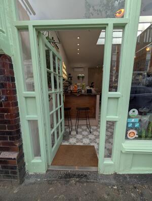 Mint green wood-framed glass door. Push from handle on left to open.
