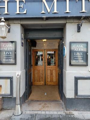 Black wooden door ahead. Push from centre to open.